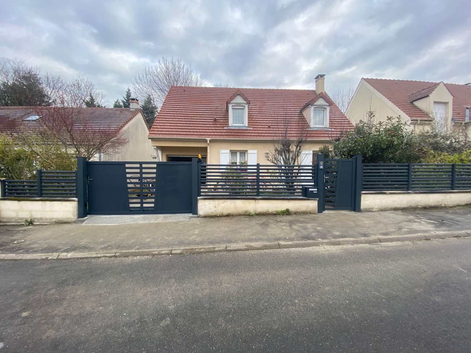 Portail coulissant et clôture aluminium posés devant une maison